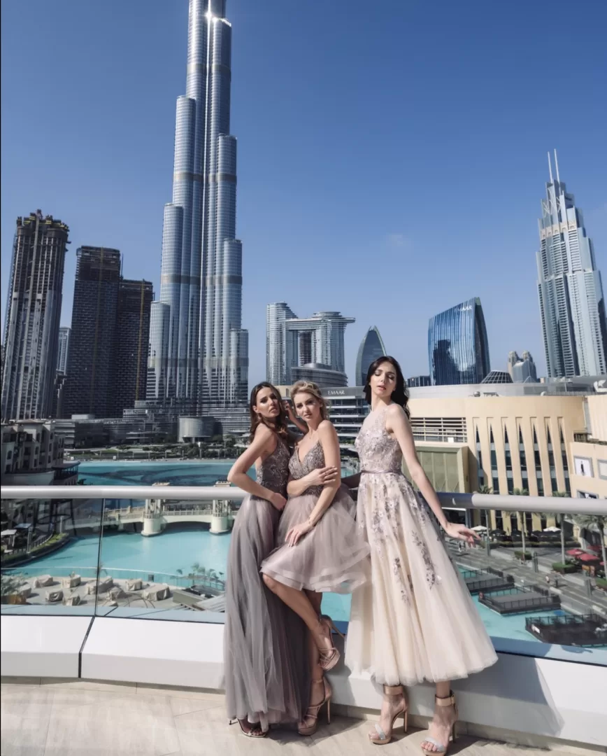 Three models in dresses posing with Dubai skyline and Burj Khalifa — fashion shoot in Downtown Dubai - dubai photographer